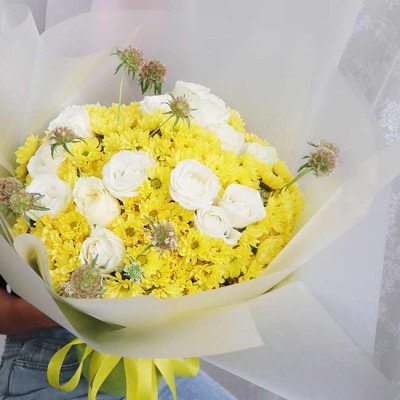 Yellow daisies and white roses bouquet with scabiosa and yellow ribbon.