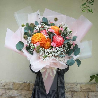 Bouquet of orange and pink chrysanthemums with baby's breath and eucalyptus.