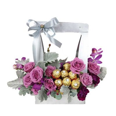 A white box filled with purple roses, Ferrero Rocher chocolates, and purple orchids.