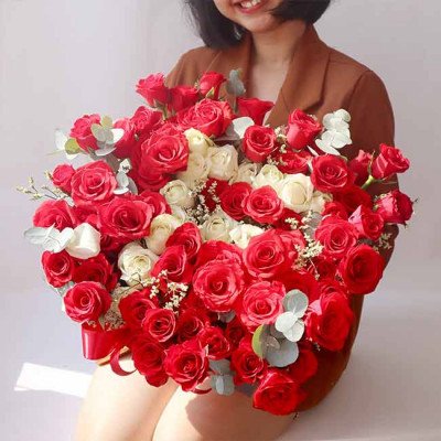 Bouquet of red and white roses with a person holding them.