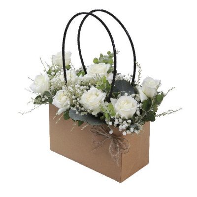 Brown paper flower bag with white roses and baby's breath.