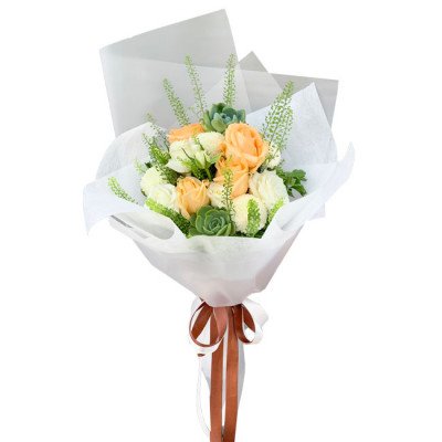 Peach and white roses with succulents and greenery in a white paper bouquet.