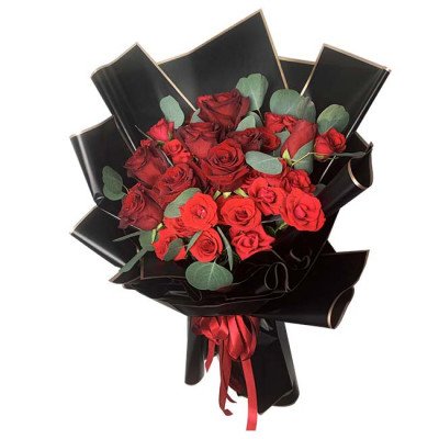 A large bouquet of red roses with black wrapping and red ribbon.