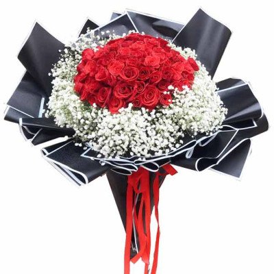 A bouquet of 99 red roses and baby's breath wrapped in black paper with red ribbons.