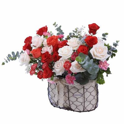 A basket of red and white roses with eucalyptus and pink carnations.