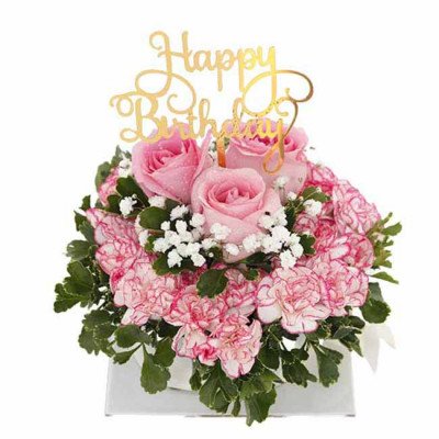 Pink roses, carnations, baby's breath, and greenery in a white box with a "Happy Birthday" topper.