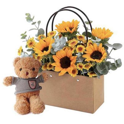 Teddy bear with bouquet of sunflowers in a gift bag.