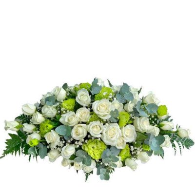 Floral arrangement of white roses and green filler flowers with eucalyptus leaves.