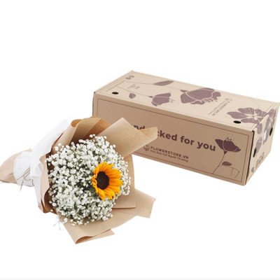 Sunflower and baby's breath bouquet next to a cardboard gift box.