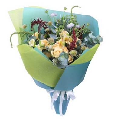 A bouquet of yellow roses, white flowers, and greenery wrapped in teal and lime green paper.