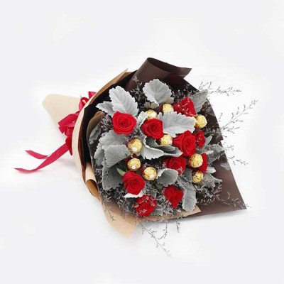 Bouquet of red roses and Ferrero Rocher chocolates, wrapped in brown and beige paper with red ribbons.