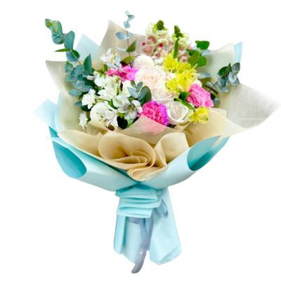 Bouquet of white roses, carnations, daffodils, and other flowers in light blue and tan wrapping.