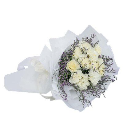 White carnation bouquet with purple filler flowers wrapped in white paper.