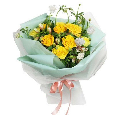 Bouquet of yellow roses and white flowers wrapped in light green and white paper, tied with a pink ribbon.