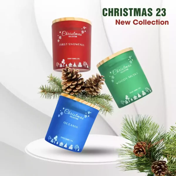 Three Christmas scented candles in red, green, and blue jars with pinecones and festive decorations.
