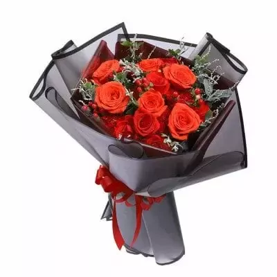 Bouquet of red roses and carnations in dark grey wrapping with a red ribbon.