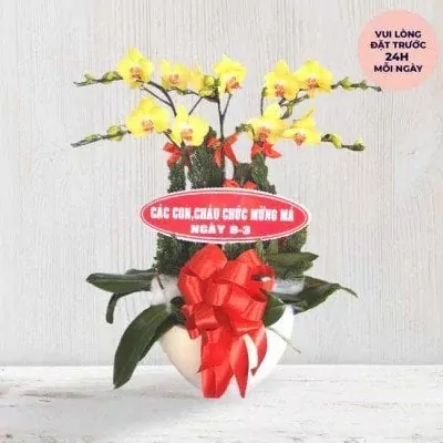 Yellow orchid plant with "Happy Mother's Day" message and red bow in a white pot.