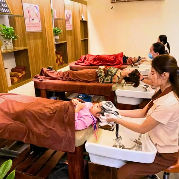People relaxing on beds while getting hair washed in a salon.