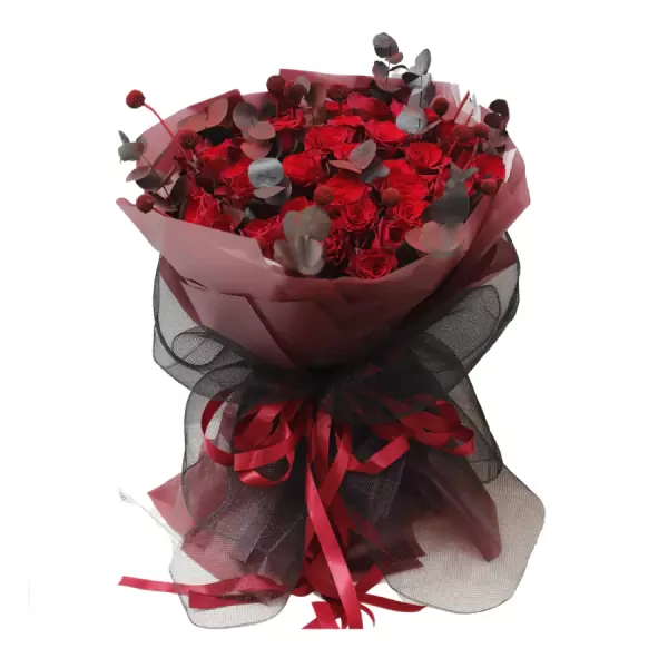 Bouquet of red roses, eucalyptus, and decorative elements wrapped in pink and black fabric.