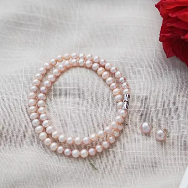 Double strand pink pearl necklace with a silver clasp and matching pearl stud earrings.