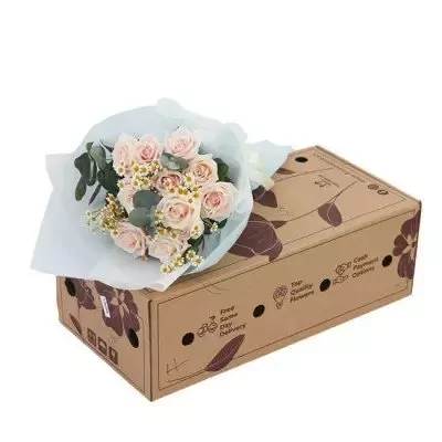 Pink roses and baby's breath bouquet on a floral patterned box.