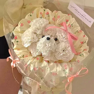 A white carnation bouquet shaped like a puppy in a floral wrapper.