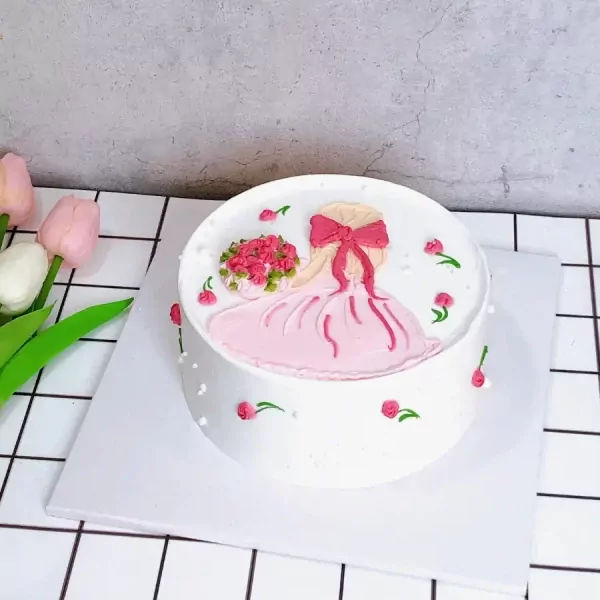 White cake with pink frosting of a girl holding flowers and wearing a dress.