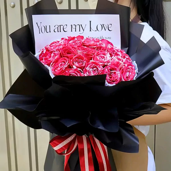 A bouquet of red and white marbled roses in black paper with "You are my Love" card and red/white ribbon.