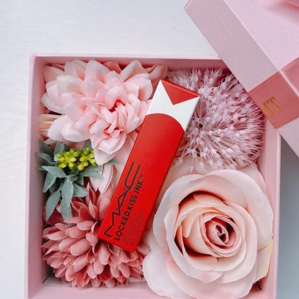 MAC 95 Vicious liquid lipstick in a pink gift box surrounded by faux flowers.