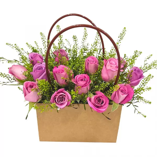 Basket of pink and purple roses with green filler flowers and a brown handle.