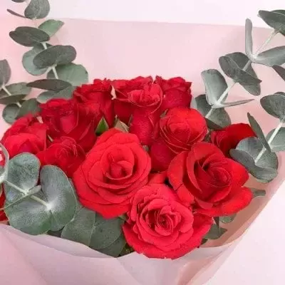 A bouquet of red roses and eucalyptus.