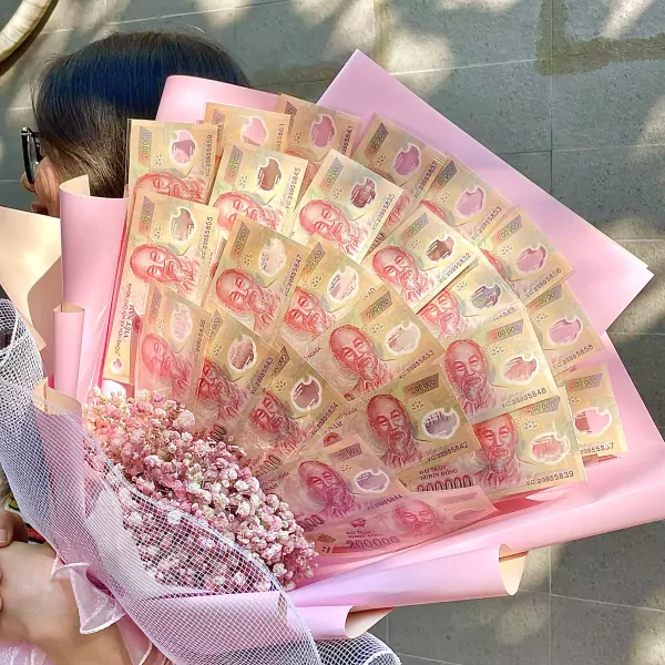 Money bouquet of Vietnamese 200,000 đồng banknotes with pink flowers and wrapping.