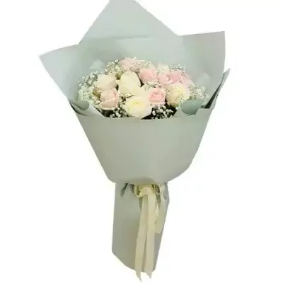 A bouquet of pink and white roses with baby's breath, wrapped in pale gray paper and tied with a cream ribbon.