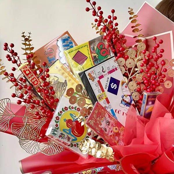 Bouquet with Monopoly, Lotteria, Horse Racing, O An Quan, and playing cards, decorated with red berries and gold accents.