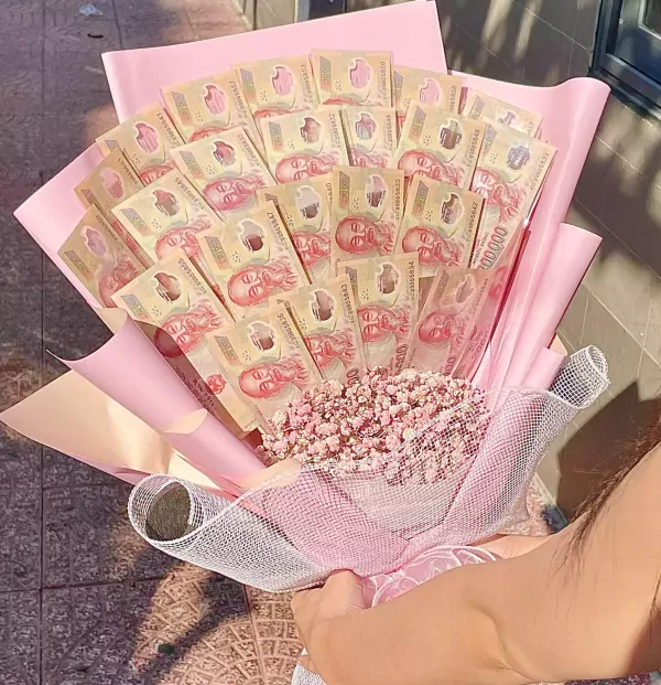 Money bouquet with Vietnamese Dong bills and pink flowers, presented in pink wrapping.