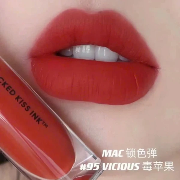 MAC 95 Vicious red liquid lipstick on lips, with product packaging.
