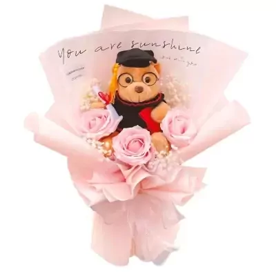 Graduation teddy bear bouquet with pink roses and baby's breath, wrapped in pink paper.