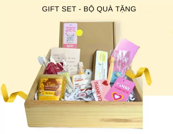 Wooden gift box with Hello Fresh body care products, including carrot body mask and bee knees scrub.