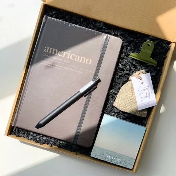 Gift set with a notebook, pen, clip, scented sachet, and sticky notes.