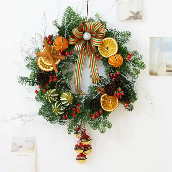 Christmas wreath with dried oranges, pinecones, berries, and ribbon bow.