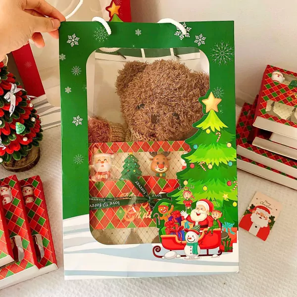 Christmas gift bag with teddy bear, Santa, reindeer, and Christmas tree decorations.