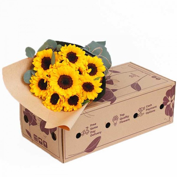 Bouquet of sunflowers in brown paper on a cardboard box with delivery information.