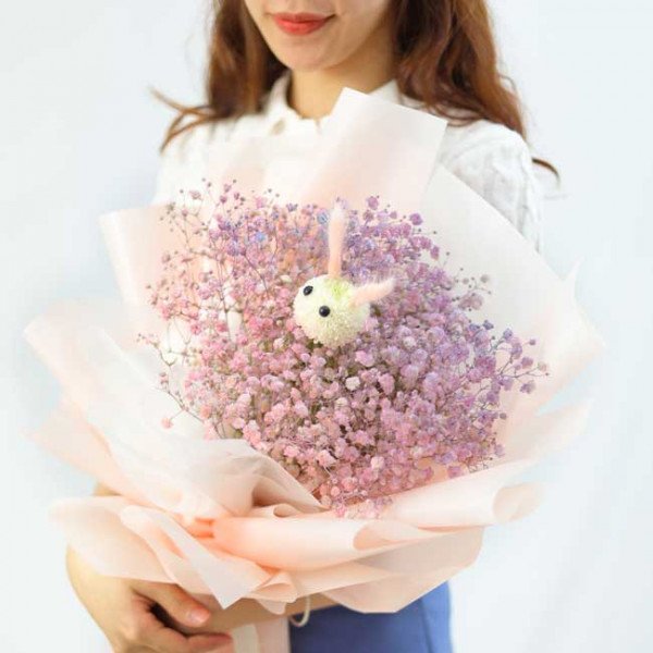 Bouquet of pink and purple baby's breath with a fuzzy bunny in the center.