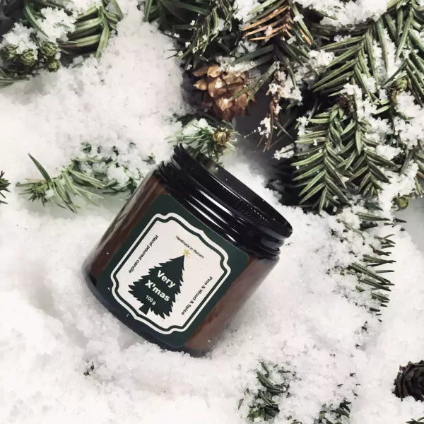 A Christmas scented candle with a pine, wood, and spice scent.