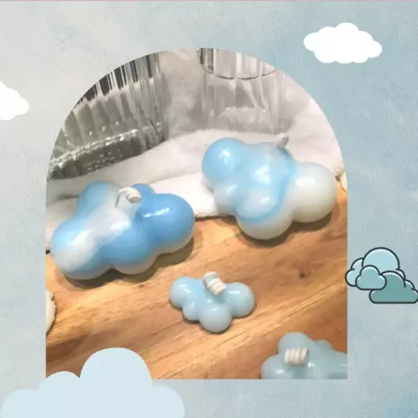 Cloud-shaped candles in blue and white swirling patterns on a wooden surface.