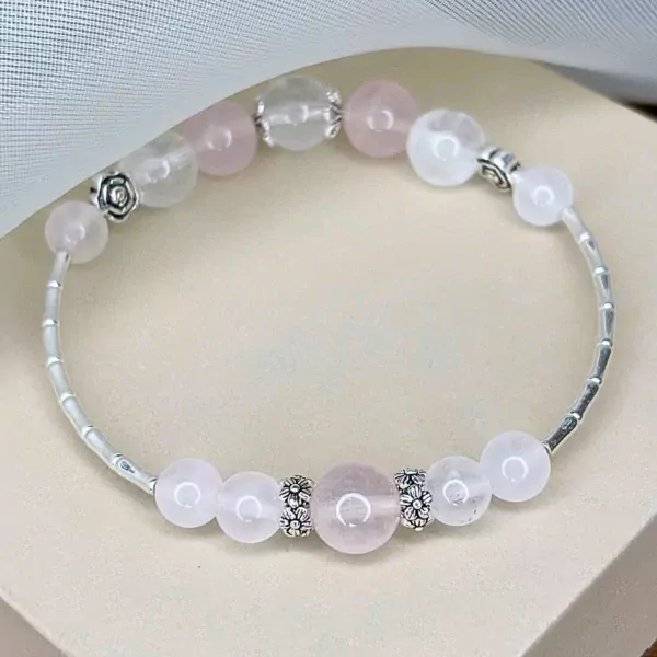 Ethereal Bloom bracelet with rose quartz, moonstone, and silver charms.