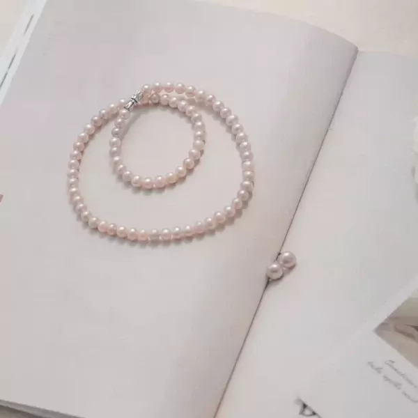 Pearl necklace and earrings on an open book.