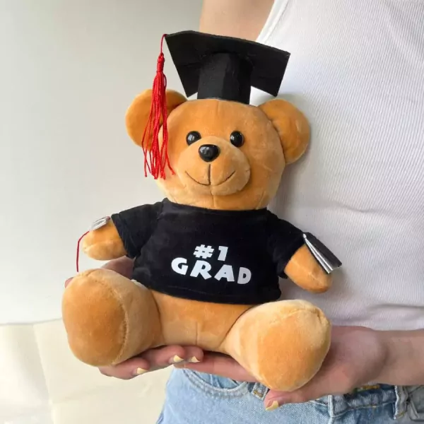 Graduation teddy bear wearing a cap and "1 GRAD" shirt.