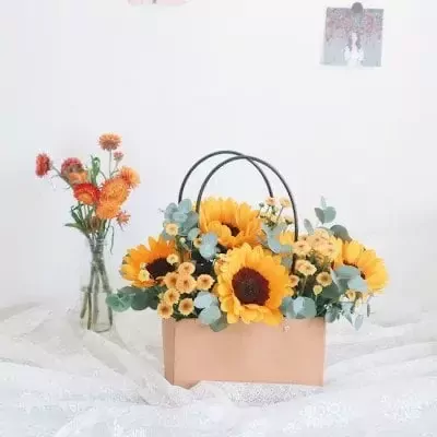 Basket of sunflowers and yellow daisies with eucalyptus.