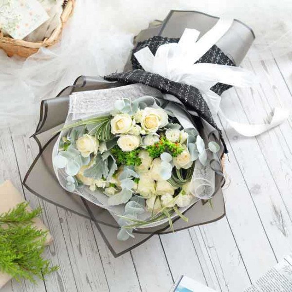 White rose bouquet with eucalyptus and accents, elegantly wrapped.